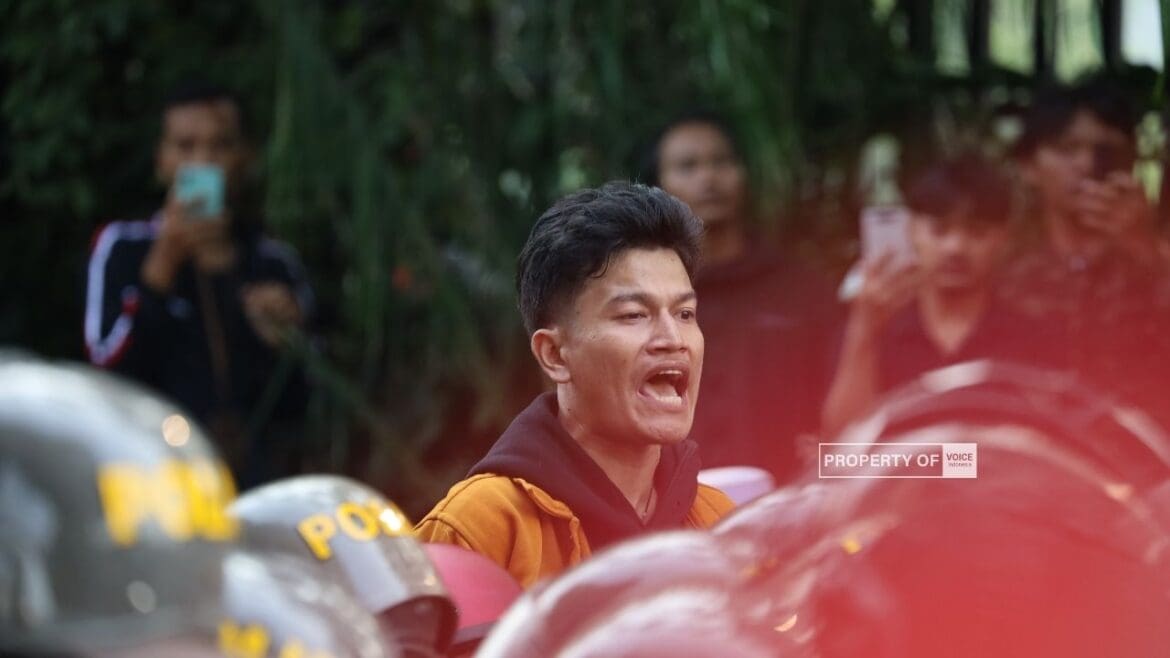 Foto : Salah satu pengunjuk rasa berdiri di kerumunan meminta teman-temannya bertahan saat di minta mundur oleh petugas aksi berlangsung di Jalan Letjend S Parman, depan Gedung DPR, Jakarta, Senin (25/08/2025).(dok.old.voiceindonesia.co/Anton Sahadi)